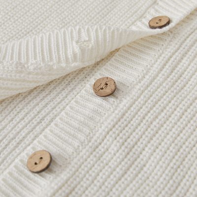 Soft cream knit cardigan with wooden buttons, stylish and comfortable for everyday wear, perfect for layered fashion, ideal for cold weather, premium quality seasonal clothing.