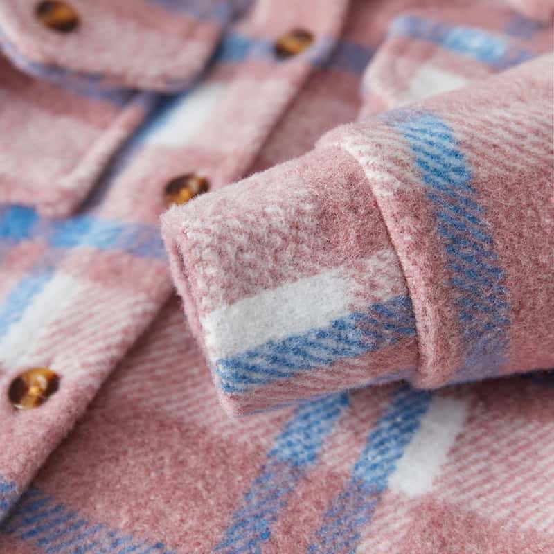 Soft pink plaid flannel shirt with blue and white accents, featuring brown buttons, perfect for cozy winter wear.