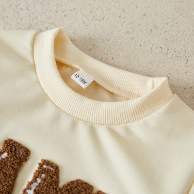 Soft cream baby sweatshirt with bear design, perfect for infant wear, cozy cotton material, available at Monalisa Store.