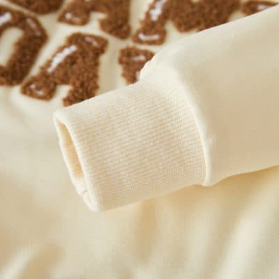 Soft cream-colored sweatshirt sleeve with ribbed cuff showcasing comfortable casual wear at Monalisa Store.
