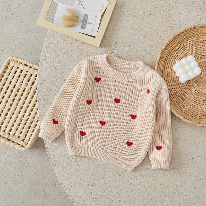Soft pink children's sweater with red heart patterns, perfect for fashionable kids' clothing and cozy winter wear. Ideal for stylish and comfortable kids' fashion collections at Monalisa Store.
