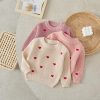 Soft knit sweaters for women, featuring heart embroidery, in pastel pink and cream colors, perfect for cozy and stylish winter wear. Ideal for casual and chic outfits.