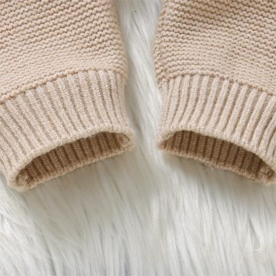 Soft beige knitted sweater sleeve close-up, comfortable and stylish knitwear. Perfect for casual wear and layering for fall and winter.