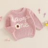 Soft pink children's knit sweater with floral embroidery, "the kid is auto one" text, and cozy design, perfect for casual wear and comfortable style.