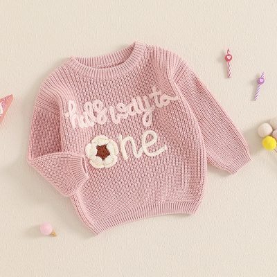 Soft pink children's knit sweater with floral embroidery, "the kid is auto one" text, and cozy design, perfect for casual wear and comfortable style.