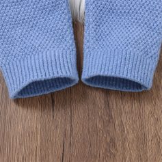 Comfortable blue knitted sweater sleeves on wooden surface, ideal for casual fashion and cozy style. Suitable for everyday wear, showcasing warm, soft fabric and modern design. Perfect for winter or fall outfits.