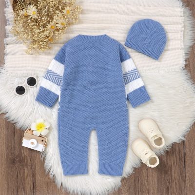 Soft blue knit baby romper with white and gray striped sleeves and matching beanie hat, perfect for winter; displayed on a cozy white rug.