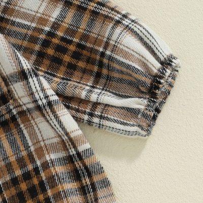 Plaid fabric sleeve detail on clothing, stylish and cozy garment, perfect for fall and winter wear.