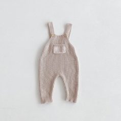 Soft beige baby knit overalls with shoulder straps, pocket detail, and ribbed cuffs, ideal for comfortable infant clothing. Perfect for stylish and cozy baby outfits.