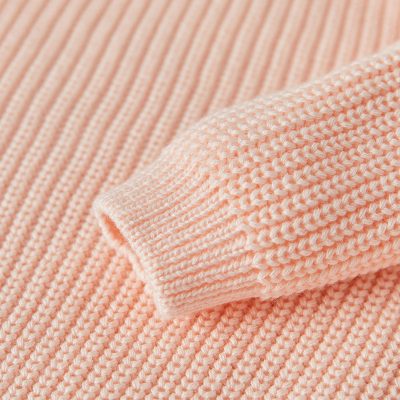 Soft peach-colored knitted sweater fabric, close-up view with detailed ribbing texture, ideal for stylish winter wear, emphasizing comfort and fashion at Monalisa Medical Store.