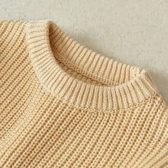 Soft beige knitted sweater with ribbed collar, cozy and stylish casual wear option.