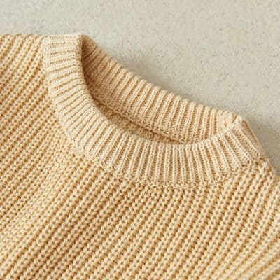Soft beige knitted sweater with ribbed collar, cozy and stylish casual wear option.