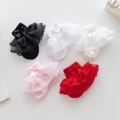 Colorful lace baby socks with bows in pink, white, black, and red, ideal for baby girls and boys, perfect for gifting or daily use, available at Monalisa Medical Store.