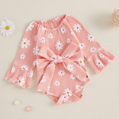 Soft pink baby romper with white daisy floral print and ruffled bell sleeves, featuring a front tie bow for cute and comfortable style. Perfect for spring and summer occasions.