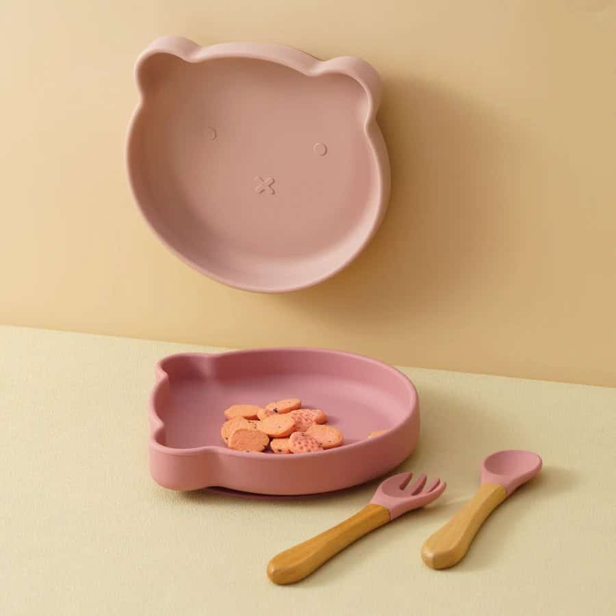 Pink bear-shaped silicone kids dinner set with plate, fork, and spoon, ideal for children's mealtime and encouraging healthy eating habits. Perfect for parents seeking durable, fun, and safe dishware for kids.