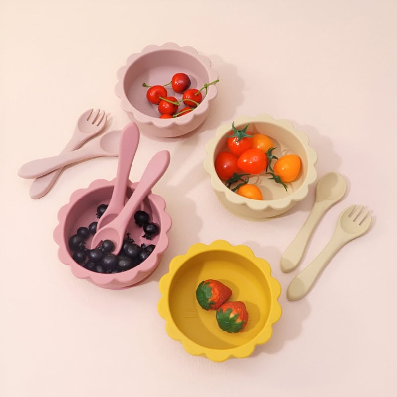 Fresh cherry tomatoes and strawberries in colorful silicone bowls with matching mini cutlery, perfect for kids' meals or playful dining experiences focused on healthy eating.