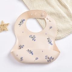 Soft pink baby silicone bib with purple floral print, adjustable fastening, and food-catching pocket, ideal for feeding time, delivers comfort and practicality for parents and babies.