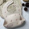 Cherry-themed baby silicone bib featuring adjustable neck straps and a food catcher, perfect for feeding time, with a cute cherry print design for infants.