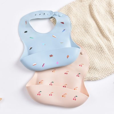Flexible baby bibs with colorful cherry and book patterns, soft silicone material, perfect for feeding time and baby care.