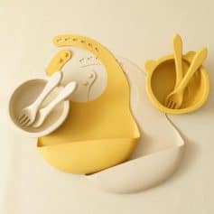 Colorful baby dining utensils set including bowls and spoons in yellow and white, designed for nursery feeding and baby care, perfect for modern parenting.