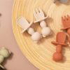 Minimalist baby teether toys on wooden plate, safe silicone teething rings, orthodontic baby teethers for infants, soft chew toys for soothing gums, Monalisa Store baby product collection.