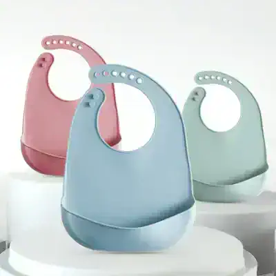 Pink, blue, and green baby bibs with adjustable neck straps, soft and comfortable, ideal for feeding and teething, perfect for infants and toddlers.