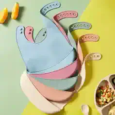Silicone bibs in pastel colors for baby feeding, designed with adjustable neck straps for a comfortable fit, ideal for preventing messes during meals.