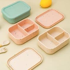 Multicolored speckled bento boxes with separate compartments, ideal for kids' meals and lunch organization. Bright, fun design perfect for healthy eating and stylish storage.