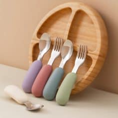 Colorful baby utensils set on a wooden tray, perfect for infants, children, and Montessori feeding accessories. Ideal for baby care, toddler feeding devices, and nursery essentials.