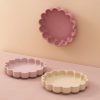Cute pink and beige Hello Kitty-shaped silicone trays, perfect for cosmetics or small storage, displayed on a soft pink surface. Ideal for organizing essentials with a playful design.