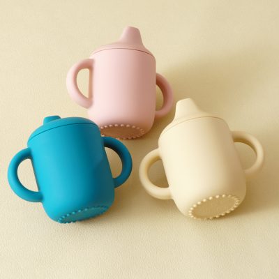 Colorful baby sippy cups in pink, blue, and cream, ideal for infant feeding, displayed on a neutral background. Perfect for promoting baby care and feeding essentials on the Monalisa Store website.