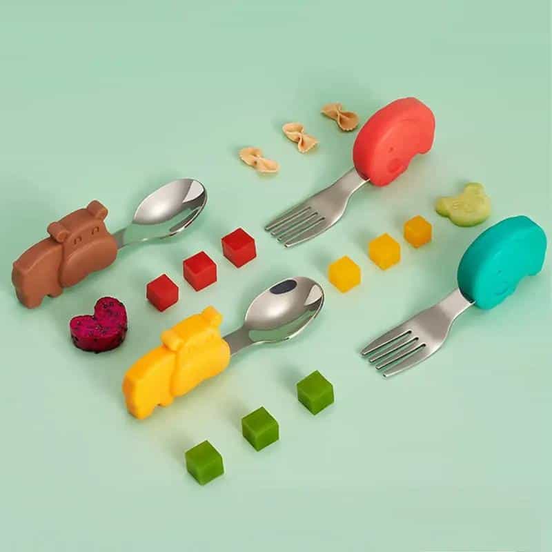 Colorful children's cutlery set with animal-shaped handles and matching food-shaped blocks, perfect for kids' mealtime fun and learning.