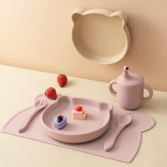 Soft pink bear-shaped kids' dinnerware set with plates, utensils, and a sippy cup, perfect for children’s mealtime, made from BPA-free durable materials, ideal for fun and safe dining experiences.