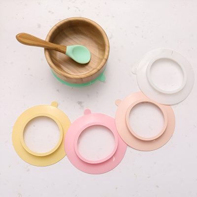 Colorful silicone eye patch removers in pastel shades with a wooden bowl and applicator on white background.