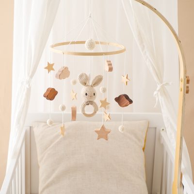 Soft baby crib with cozy pillow and plush bunny mobile for infant nursery decor, ideal for gentle sleep and sensory development. Perfect for ensuring a calming bedtime environment for babies.