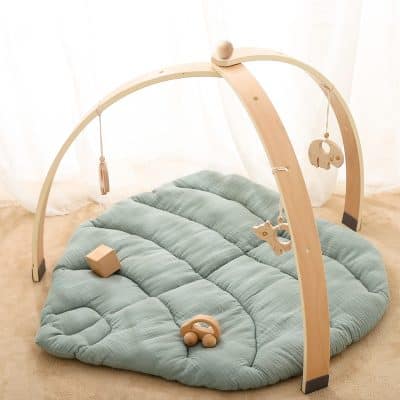 Soft baby play gym with hanging toys on a plush mat, perfect for newborns and infants. Ideal for sensory development, tummy time, and early motor skills. Bright, neutral tones suitable for modern nurseries.