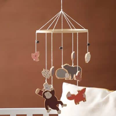 Cute wooden baby crib mobile with animal and plant charms for infant nursery decor, perfect for calming sleep and stimulating visual development. Ideal for a cozy, stylish baby's room.