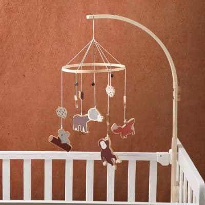 Colorful stuffed animal baby mobile hanging over a white crib, designed for nursery decor and sensory development, featuring bears, foxes, and other woodland animals.