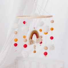 Colorful Boho Baby Mobile with Rainbow and Pom Balls, soft neutral tones, ideal for nursery decor, handmade, playful design for infants and toddlers.