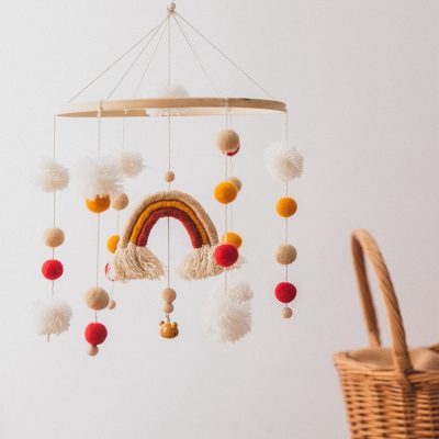 Colorful baby mobile with pom-poms and rainbow design, ideal for nurseries, baby cribs, and kids' bedrooms, adding cute and colorful decor to create a soothing environment.