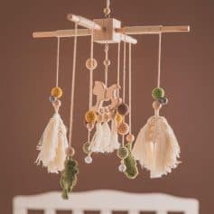 Handmade baby crib mobile with wooden and felt elements, soft tassels, and playful animal figures for nursery decor.