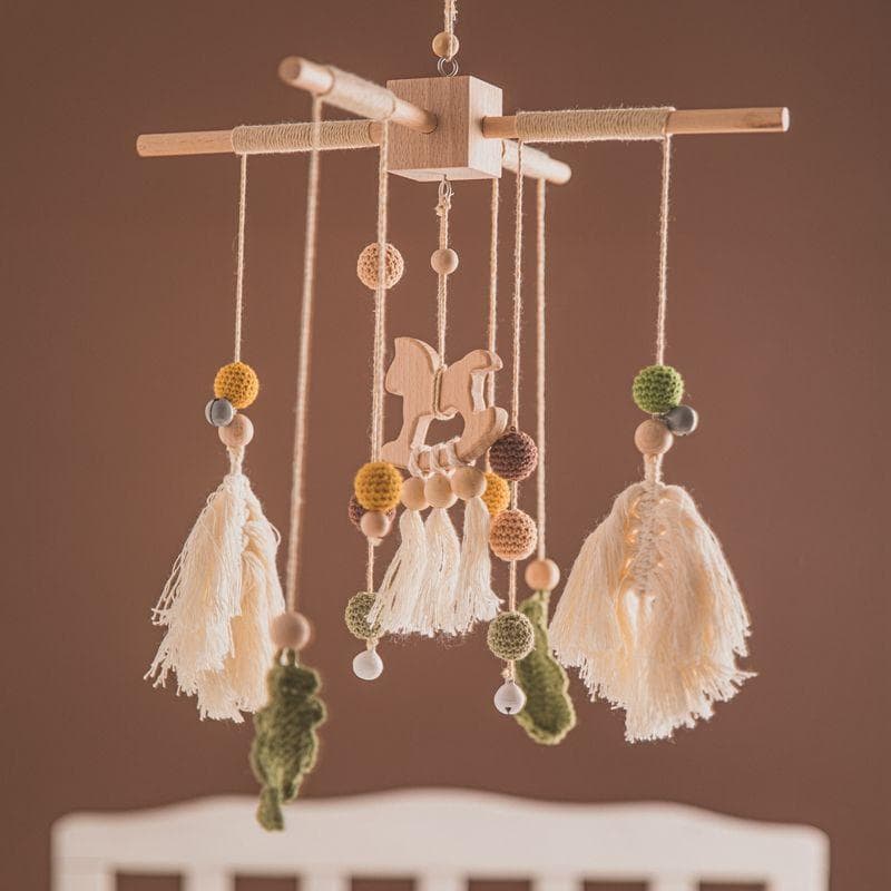 Handmade baby crib mobile with wooden and felt elements, soft tassels, and playful animal figures for nursery decor.