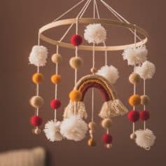 Soft baby mobile with felt pom-poms and rainbow decoration for nursery decor By Monalisa Medical.