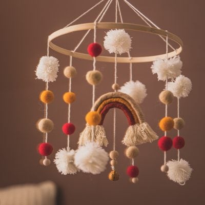 Soft baby mobile with felt pom-poms and rainbow decoration for nursery decor By Monalisa Medical.