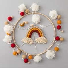 Colorful baby mobile with rainbow, pompoms, and wooden beads, perfect for nursery decor and sensory development. Handcrafted and ideal for a cozy, stimulating environment for infants.