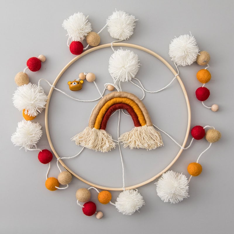Colorful baby mobile with rainbow, pompoms, and wooden beads, perfect for nursery decor and sensory development. Handcrafted and ideal for a cozy, stimulating environment for infants.