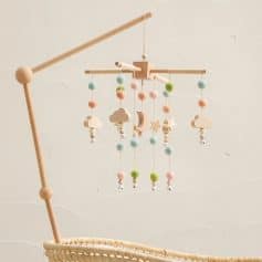 Soft pastel felt baby mobile with wooden clouds, stars, moon, and dangling beads, perfect for nursery decor and infant sensory development.