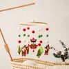 Festive felt Christmas mobile with reindeer, Santa, and trees hanging above a cozy crib in neutral tones, perfect for holiday nursery decor and enhancing holiday spirit in your baby's room.