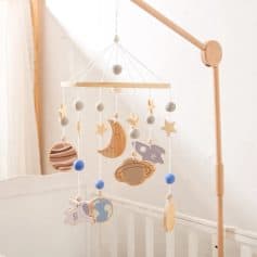 Wooden baby mobile with stars, moon, planets, and astronaut ornaments for nursery decor, crafted from natural wood and felt, creating a calming celestial theme for infants and toddlers.