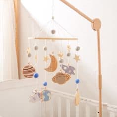Wooden baby mobile with celestial moon, star, and planet designs for nursery decor and infant stimulation.